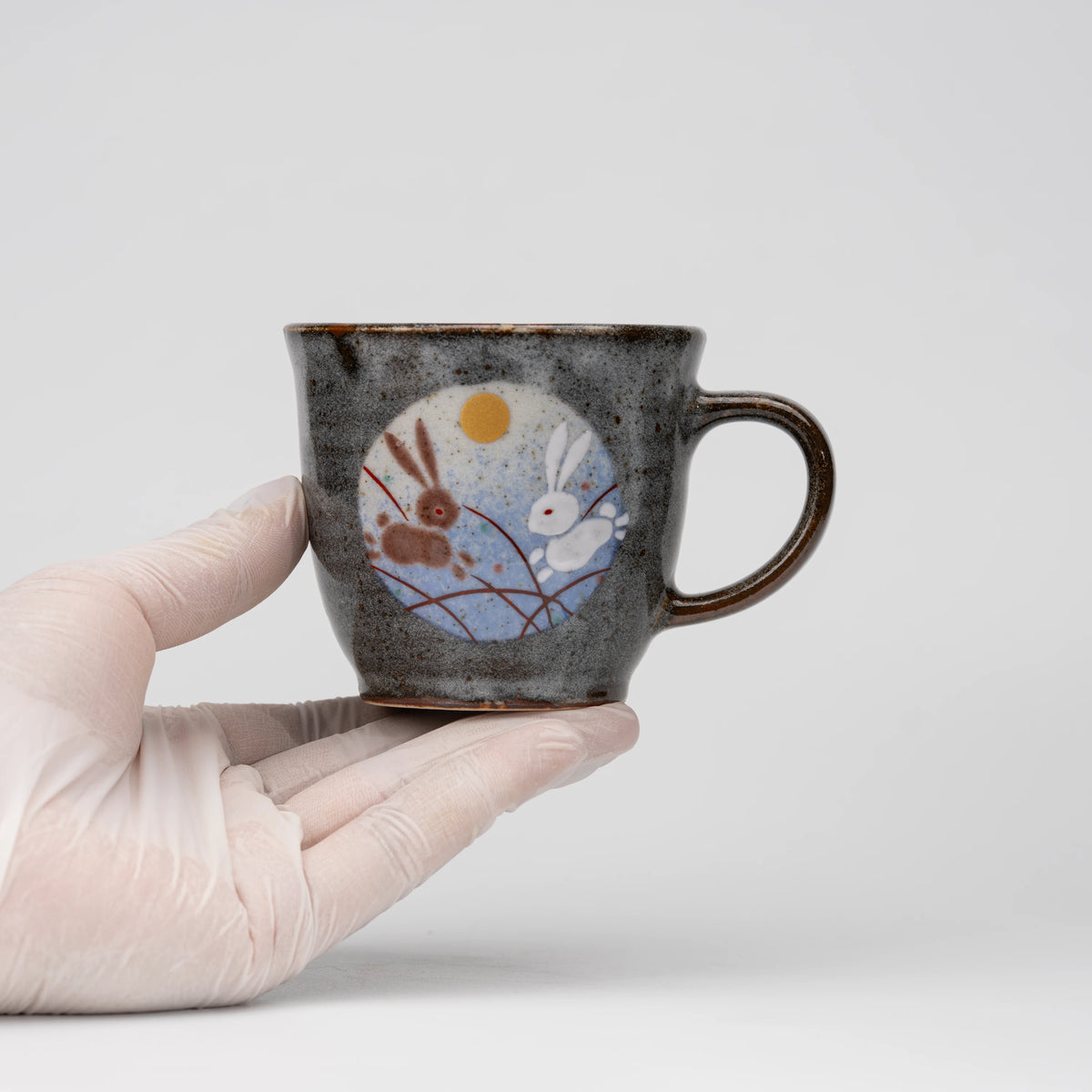 Rabbit motif mug, held in a hand to show scale.