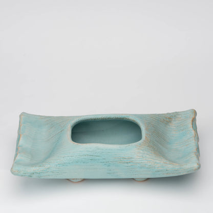 Pale blue mini ikebana vase, side view showing the shape and surface.