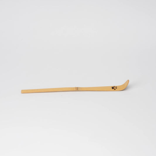 Paw-print bamboo matcha scoop, side view showing the shape and surface.
