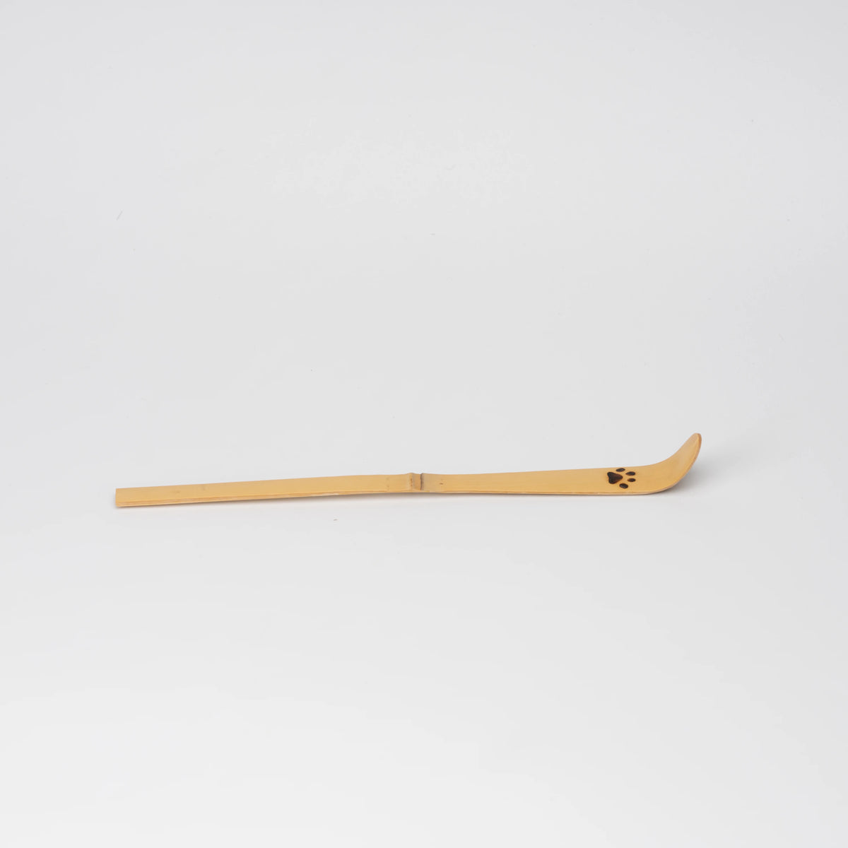 Paw-print bamboo matcha scoop, side view showing the shape and surface.