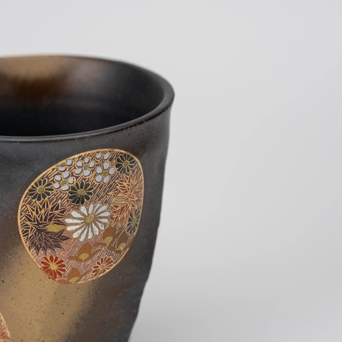 Dark floral medallion cup, side view showing the shape and surface.