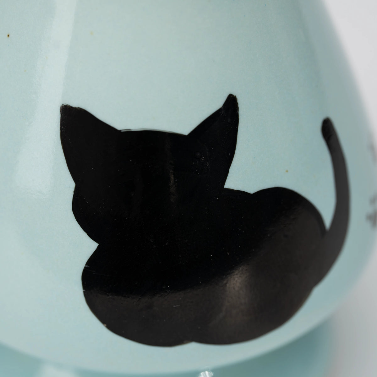 Pale blue cat whisk holder, black cat silhouette.