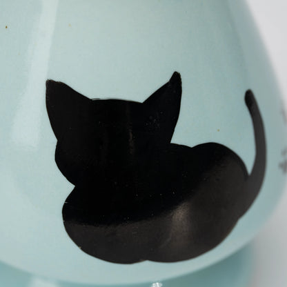 Pale blue cat whisk holder, black cat silhouette.