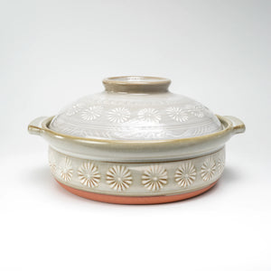 Closed gray-beige Ginpo Hana Mishima donabe with a pale floral lid and two side handles on white.