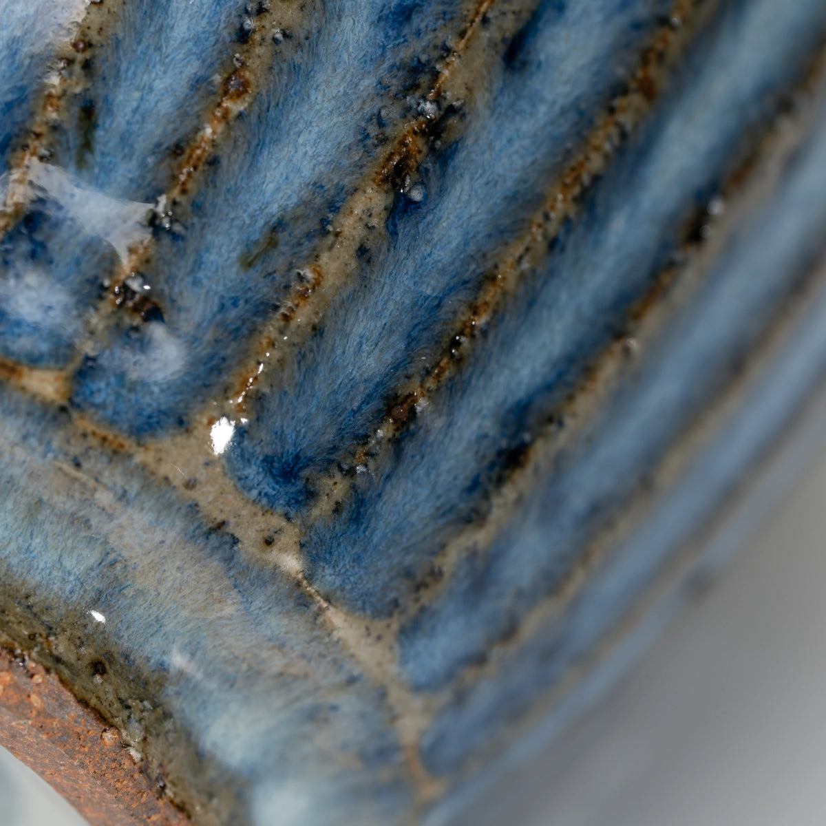 Ribbed blue-grey tea cup, vertical ribs and brown grooves.