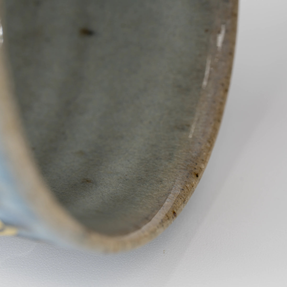 Ribbed blue-grey tea cup, rim and interior detail.