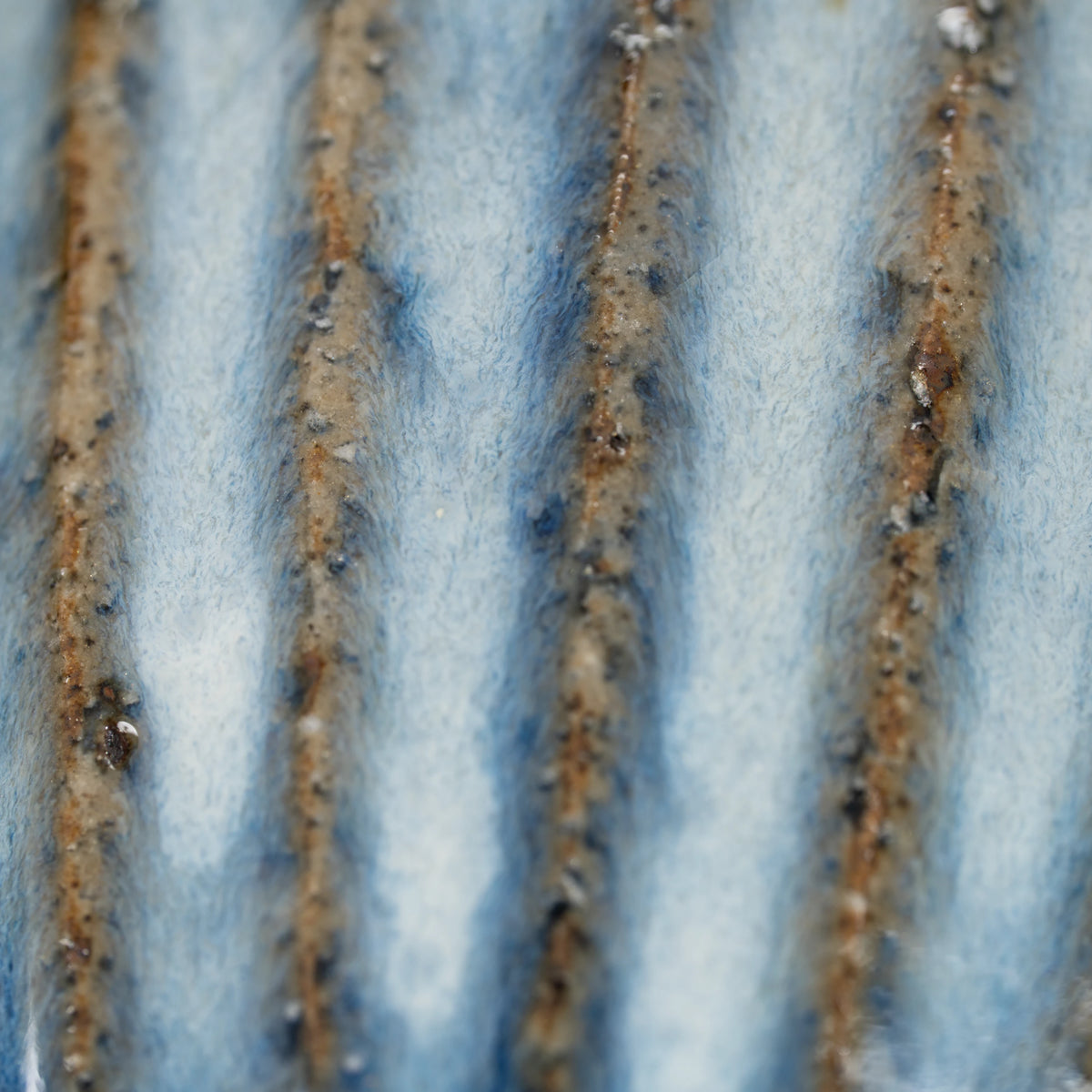 Ribbed blue-grey tea cup, vertical ribs and brown grooves.