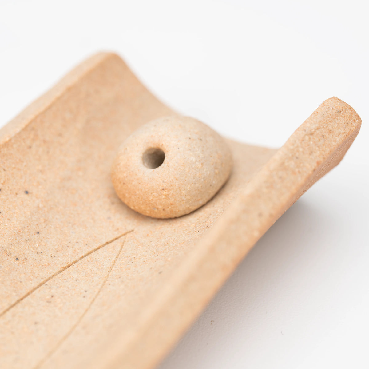Brown floral incense holder, rounded stick insert.
