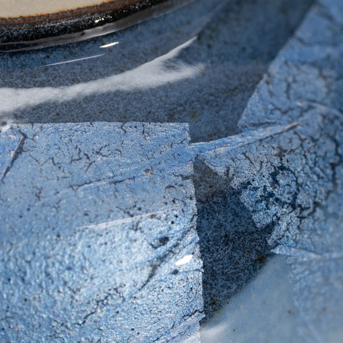 Blue ginsai matcha bowl, foil panel and glazed surface detail.