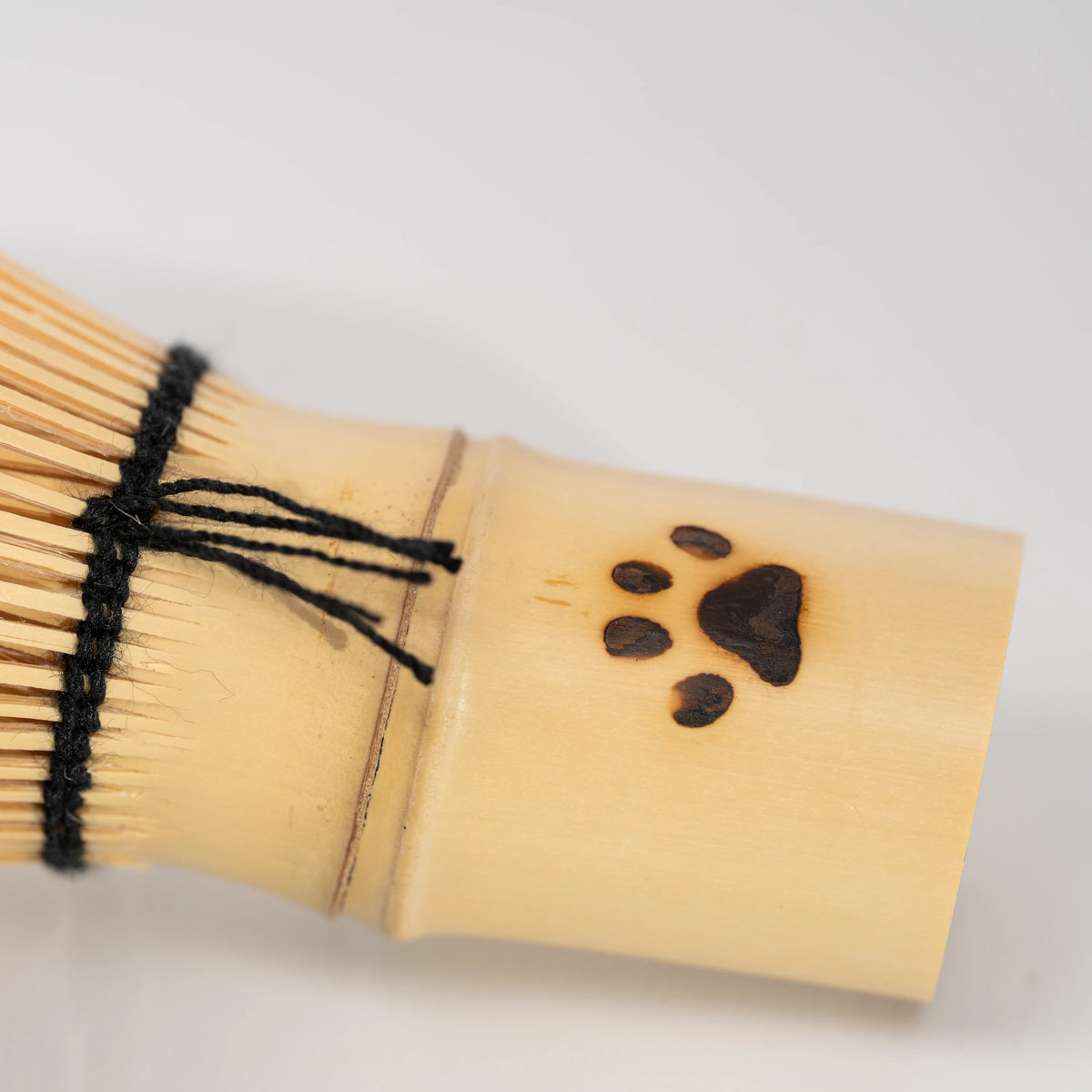 Paw-print bamboo mini whisk, paw-print handle and black thread binding.