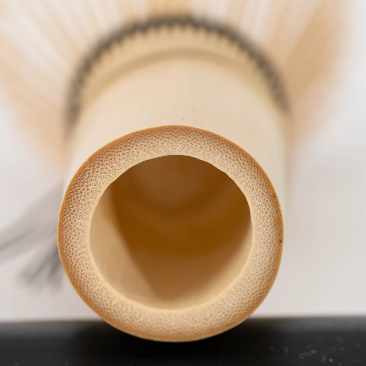 Paw-print bamboo mini whisk, hollow bamboo handle viewed from below.