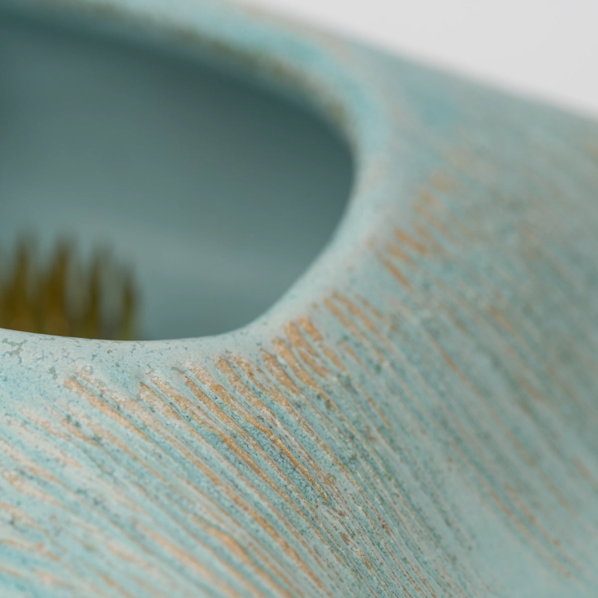 Pale blue mini ikebana vase, rectangular opening with the kenzan inside.