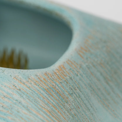 Pale blue mini ikebana vase, rectangular opening with the kenzan inside.