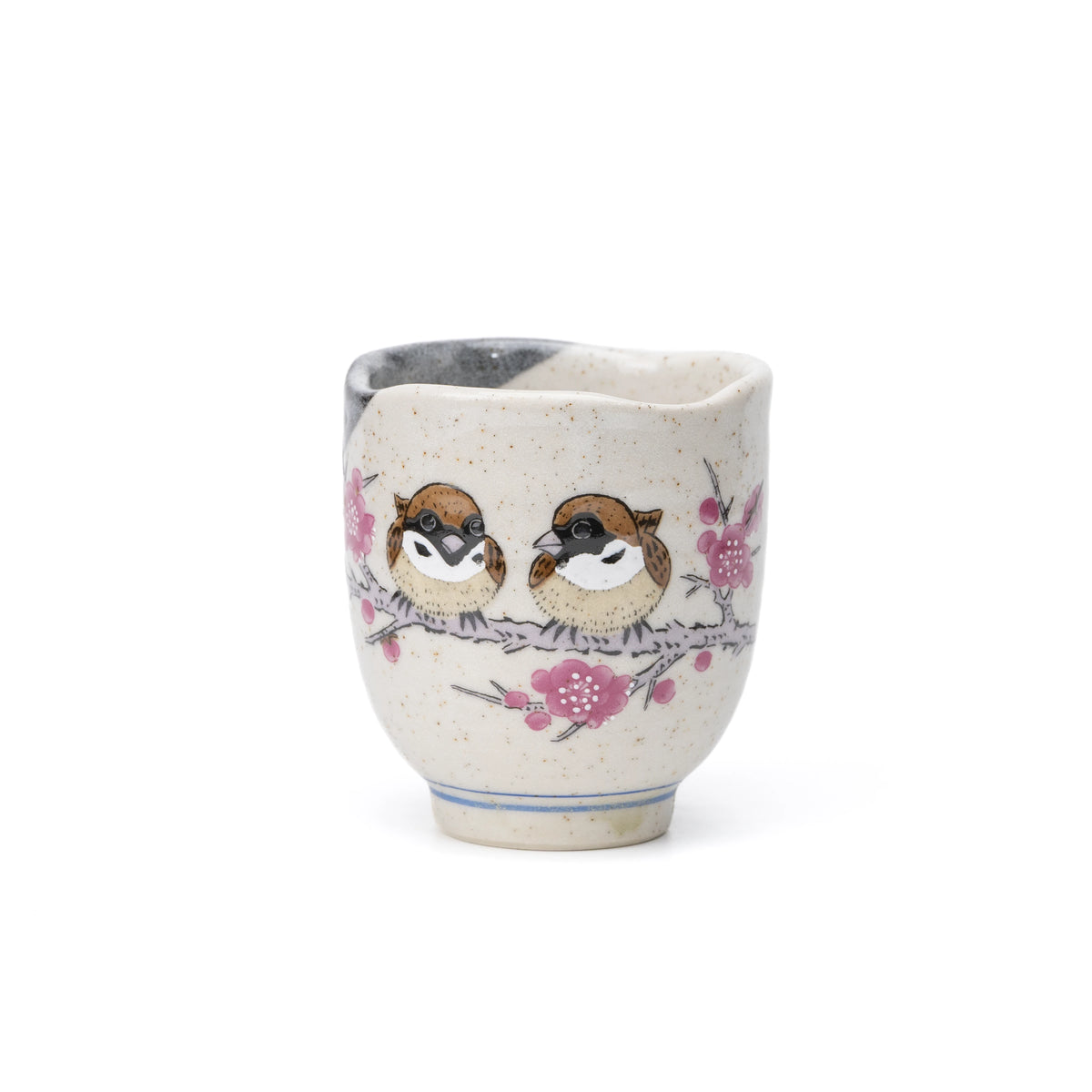 Kutani yunomi with two sparrows and pink blossoms on speckled cream glaze, on white.