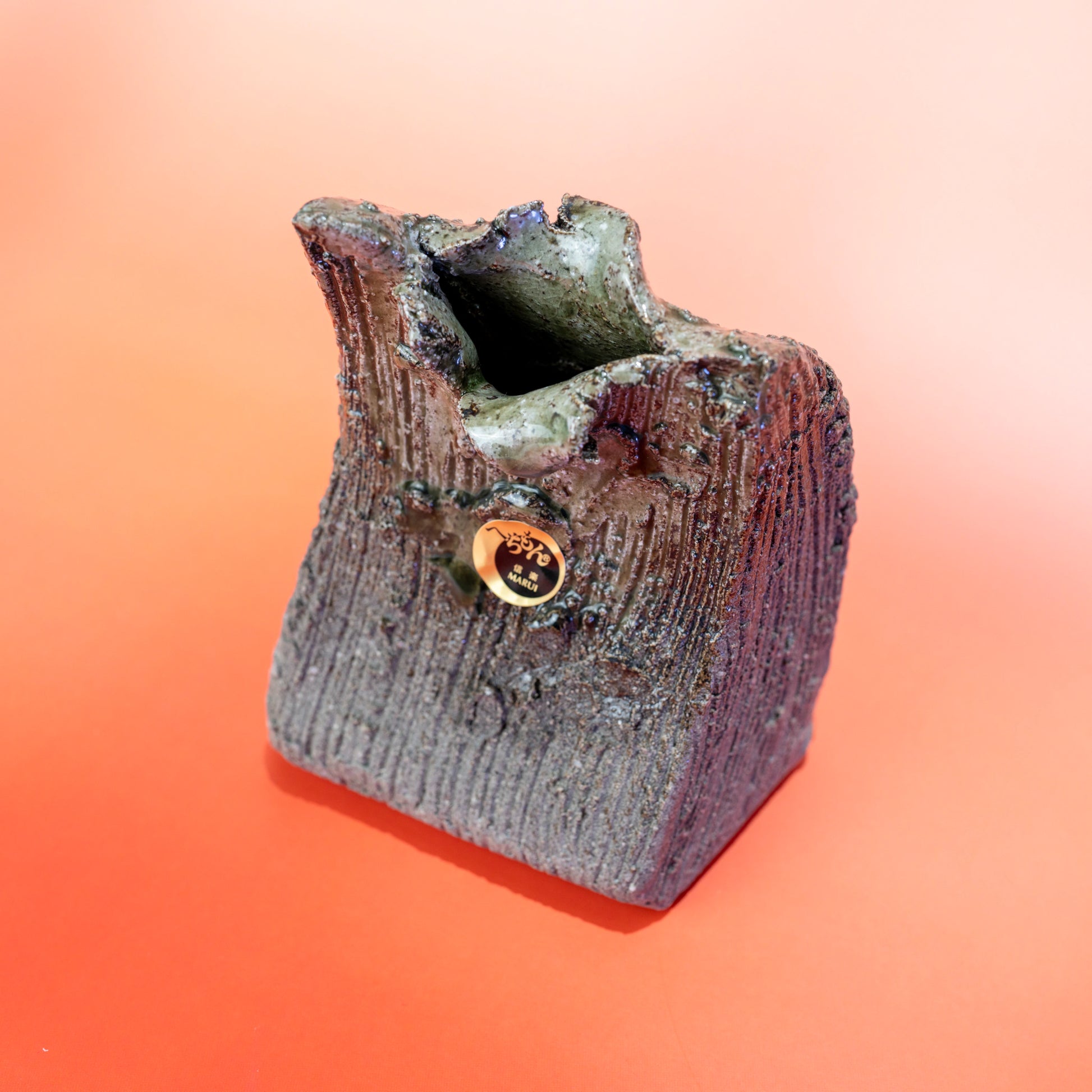 Front angled view of a Shigaraki ware bud vase with sculptural opening