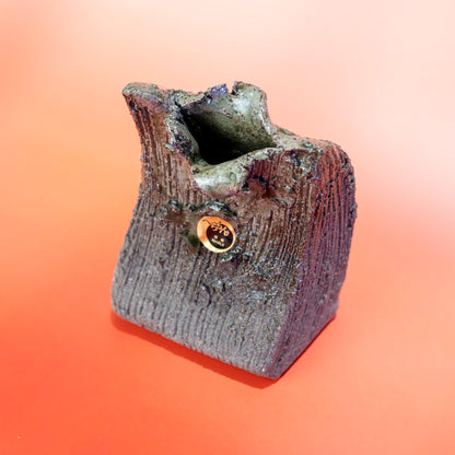 Front angled view of a Shigaraki ware bud vase with sculptural opening