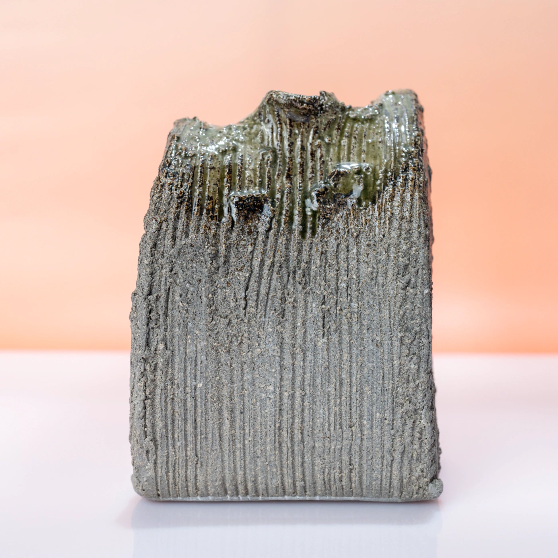Back view of a Shigaraki ware bud vase with vertical ridged texture