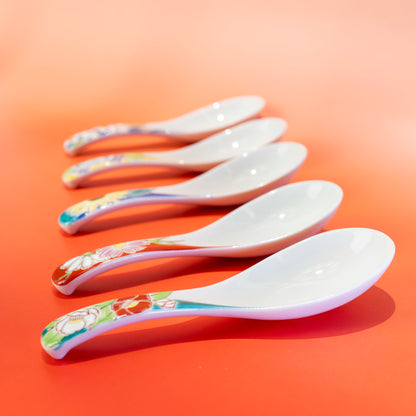 Angled view of five Kutani porcelain spoons showing curved bowls and floral handles