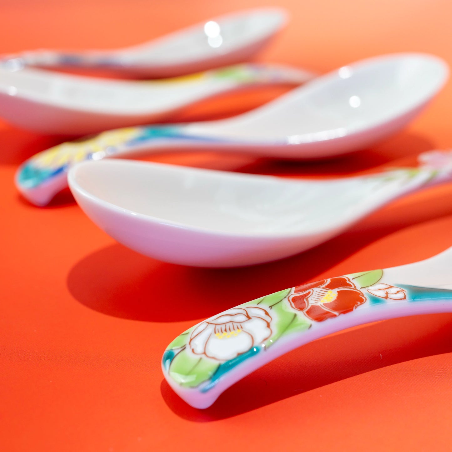 Close-up of Kutani porcelain spoons with floral handles and white spoon bowls