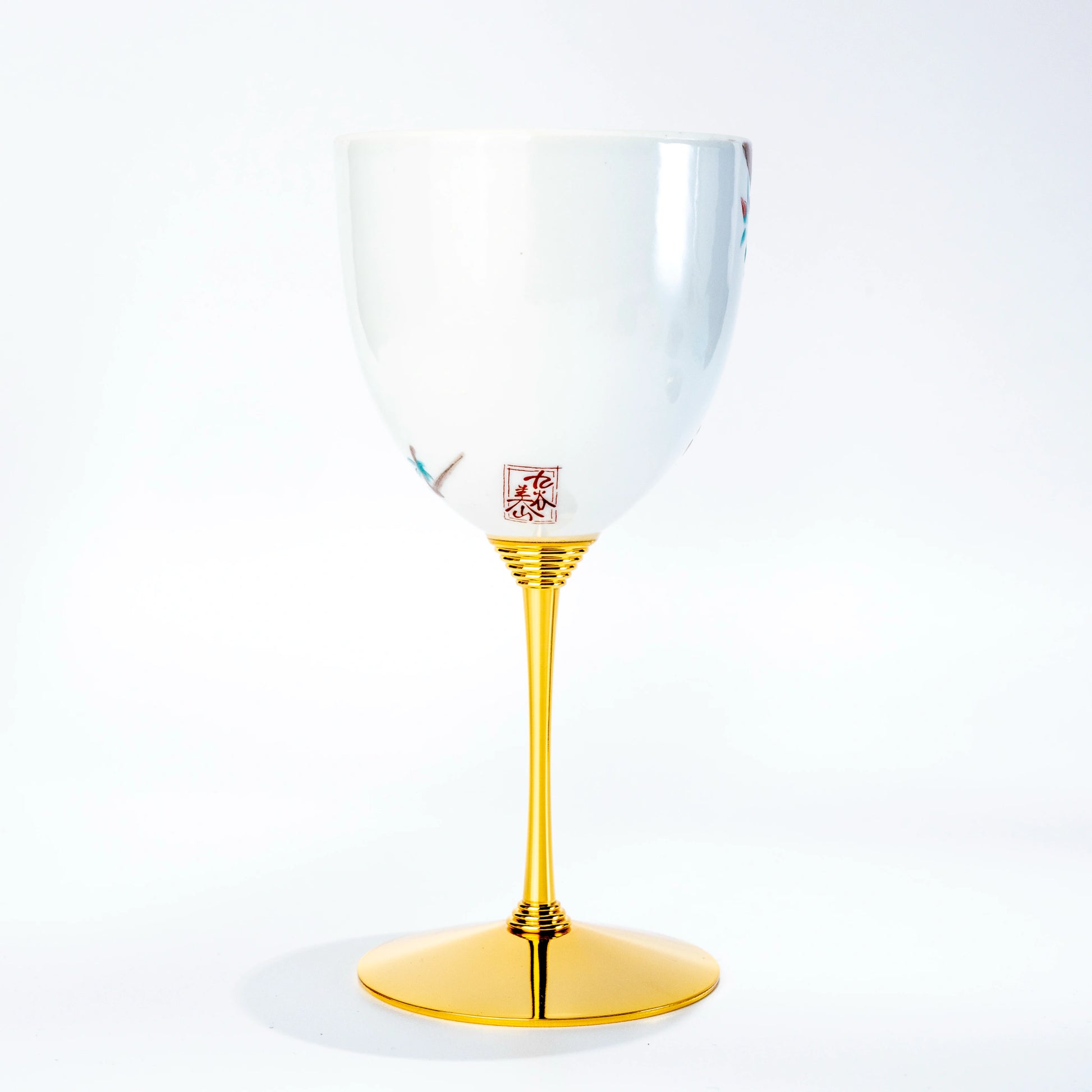 Single Kutani porcelain wine cup standing upright on a gold stem against a white background
