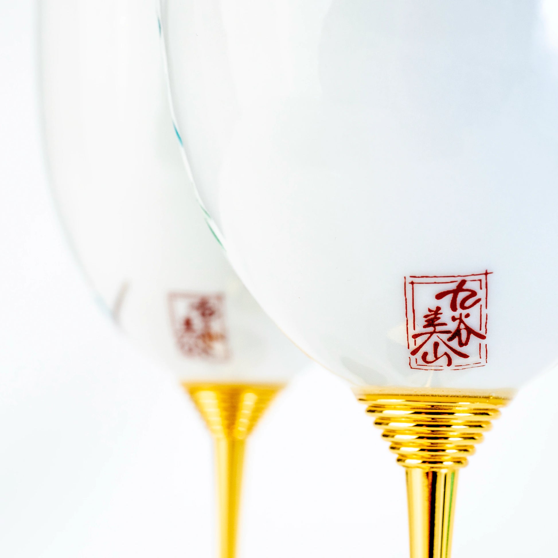 Close-up of Kutani wine cup lower bowl, red seal, and gold stem detail