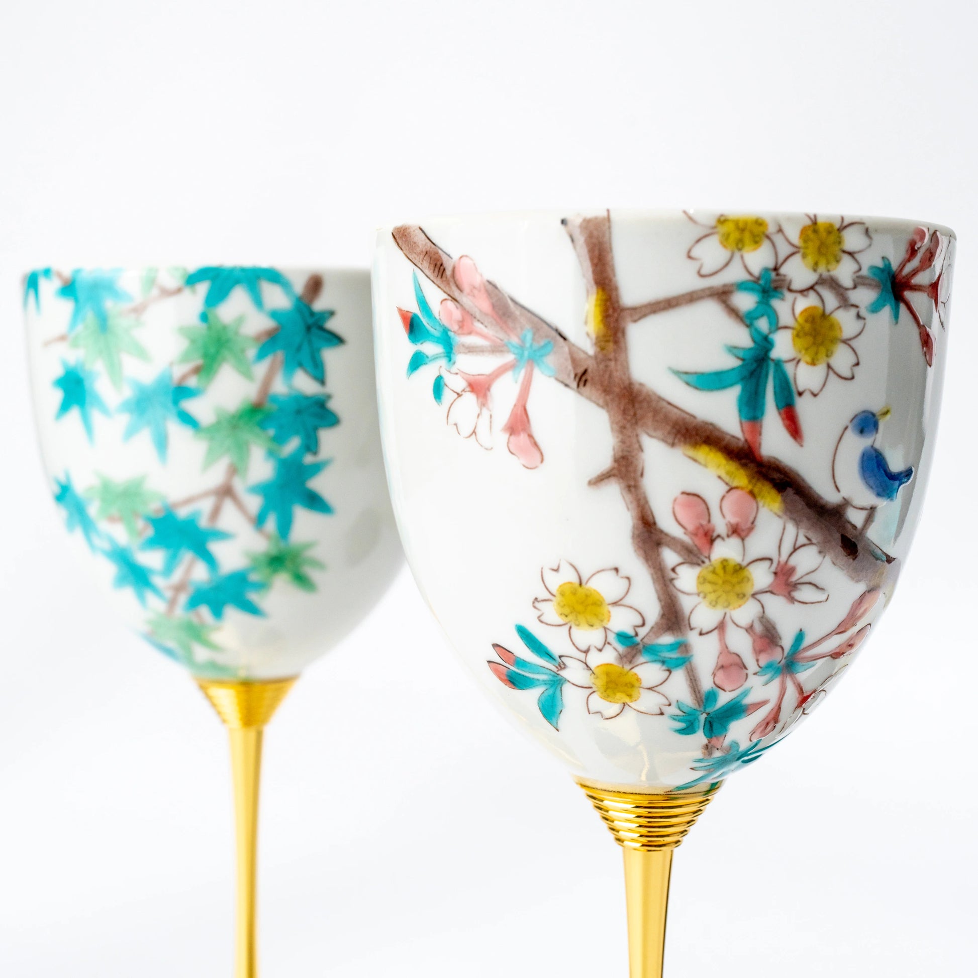 Front close-up of a Kutani wine cup pair with contrasting bird and seasonal motifs