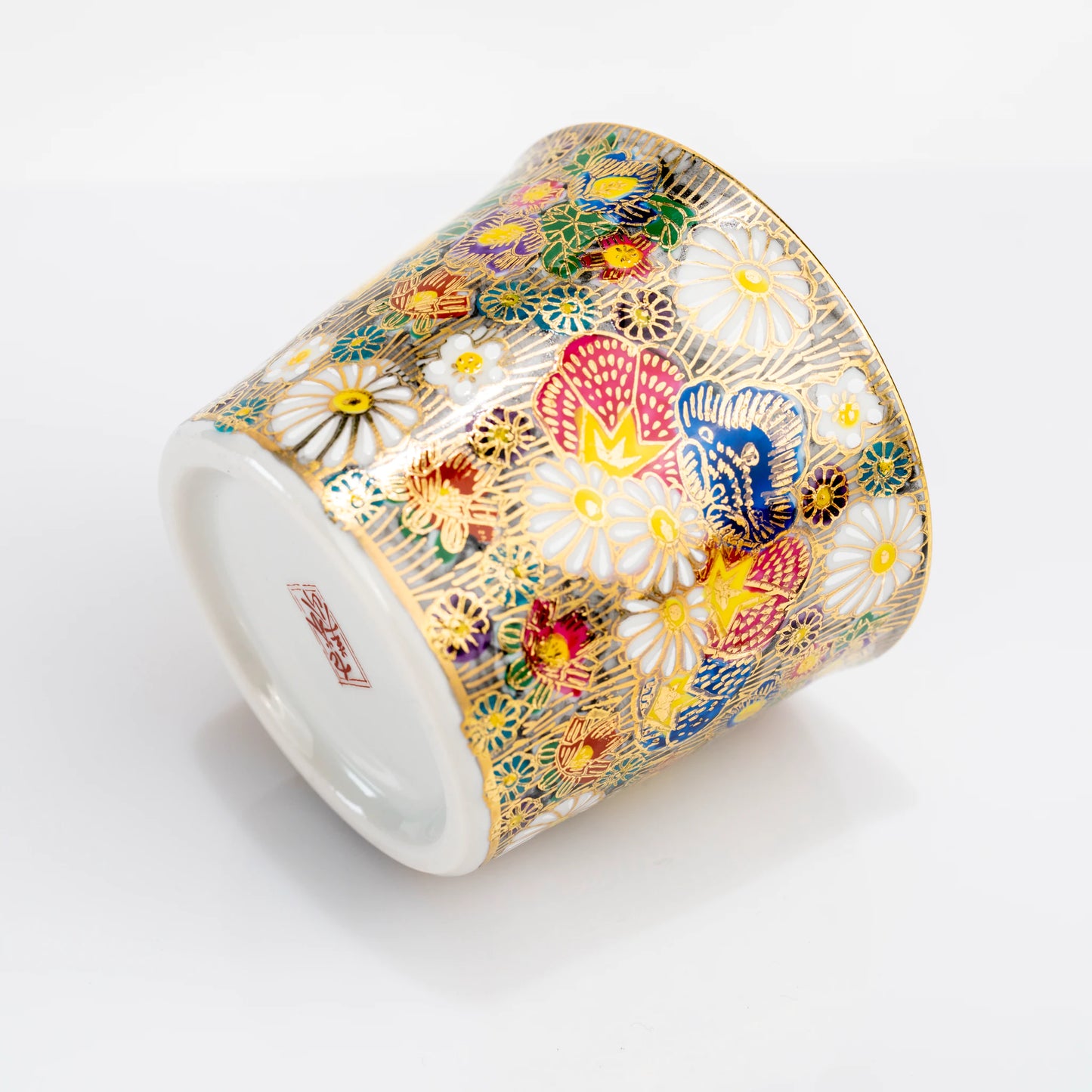 Kutani gold floral cup tilted on its side showing base and side pattern