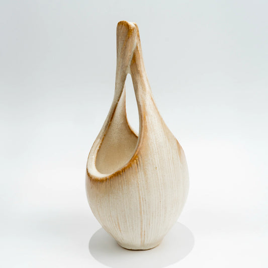 Rear three-quarter view of the tall loop vase and ribbed ceramic surface