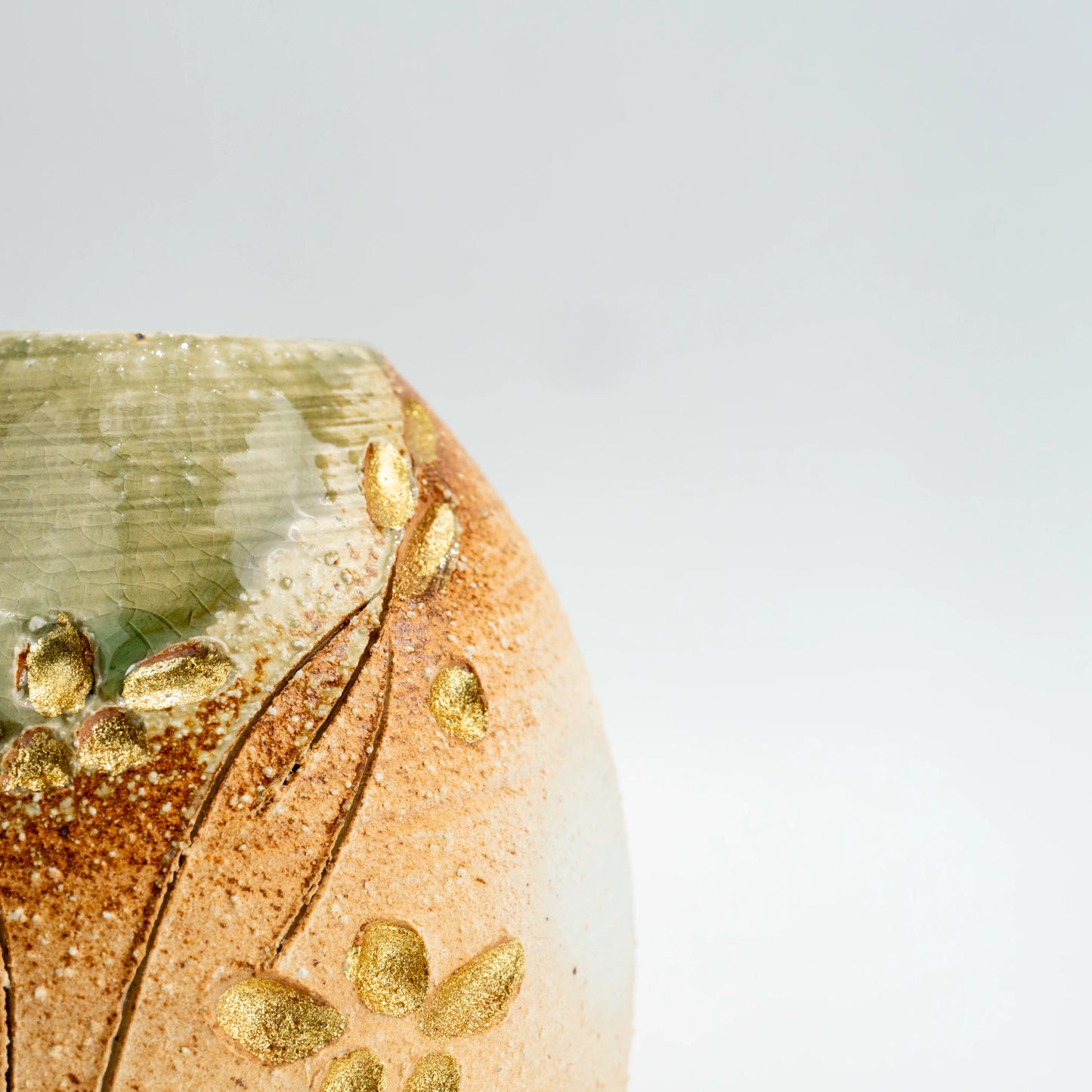 Close-up of Shigaraki vase surface showing leaf motif and green glaze detail
