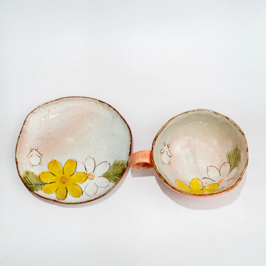 Overhead view of the pink Seto cup and matching saucer, each painted with a small rabbit and yellow and white flowers