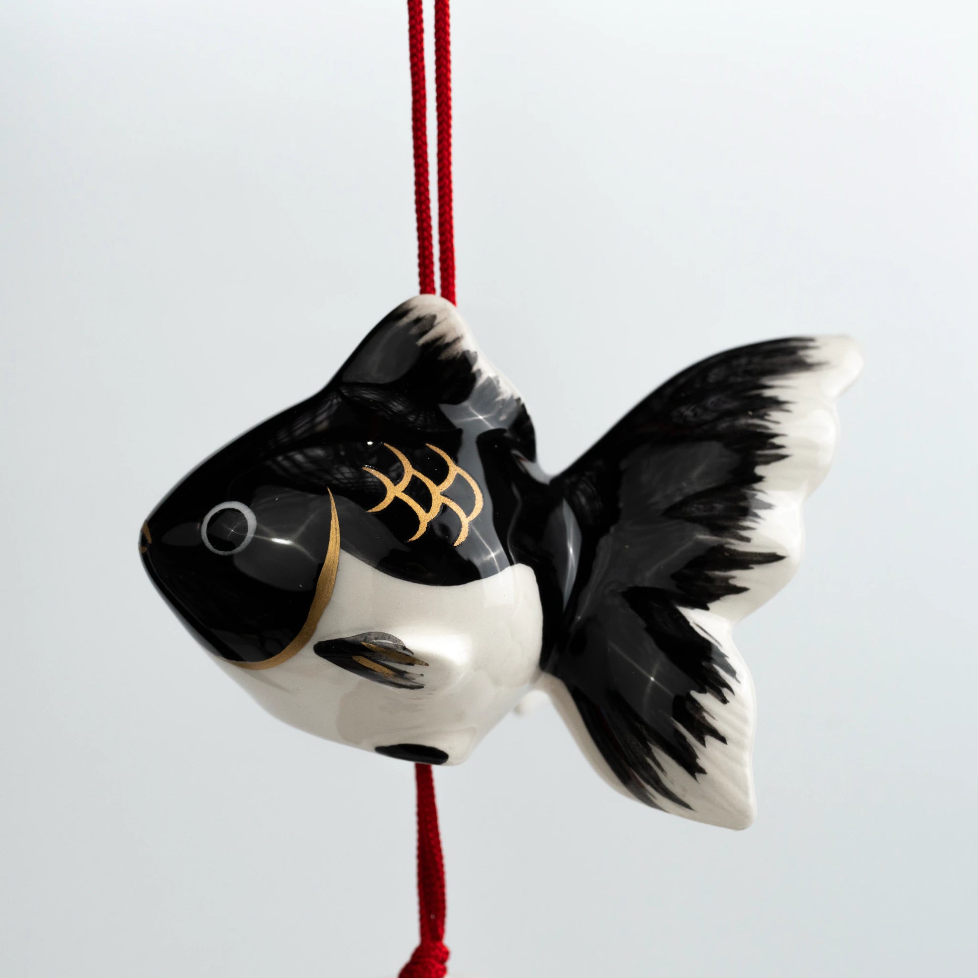 Angled close-up of black goldfish ceramic furin bell