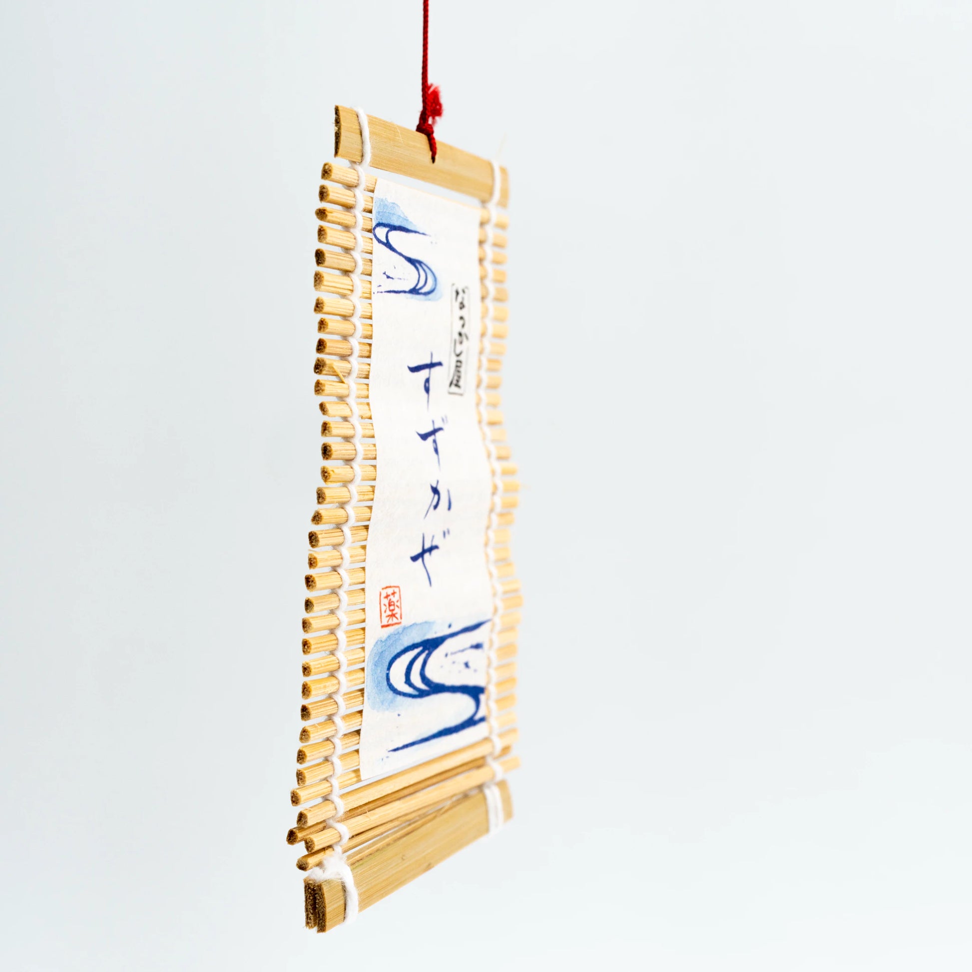 Front angle of black goldfish wind chime with hanging tag