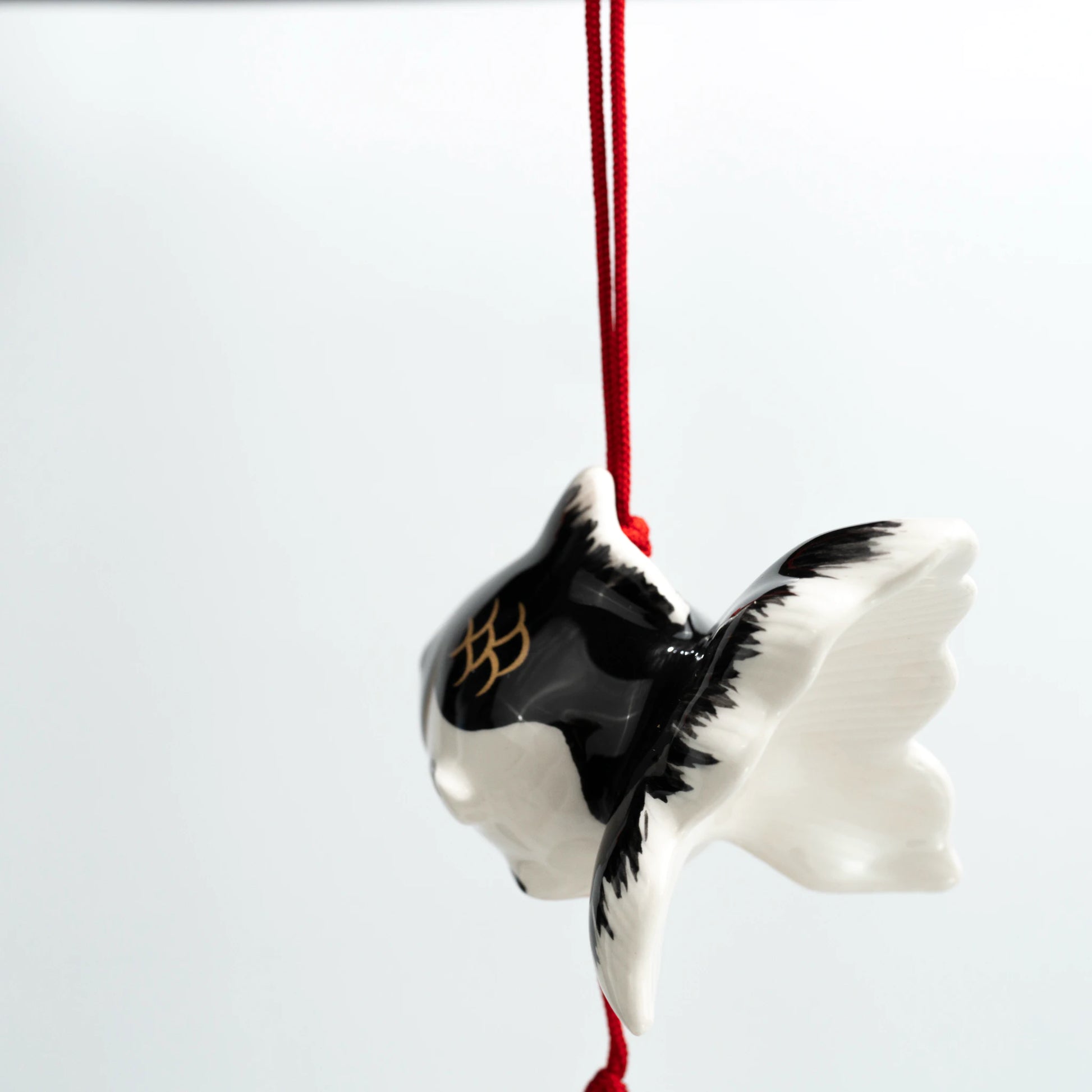 Rear view of black goldfish ceramic wind chime