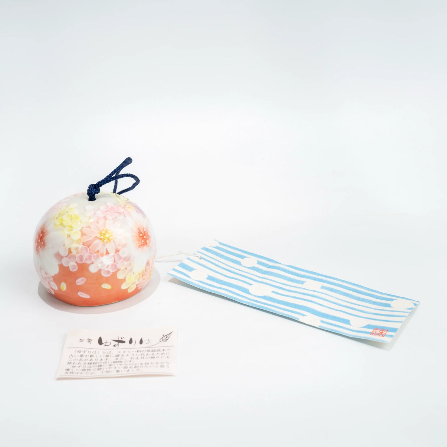 Full hanging view of pink floral ceramic furin with blue strip