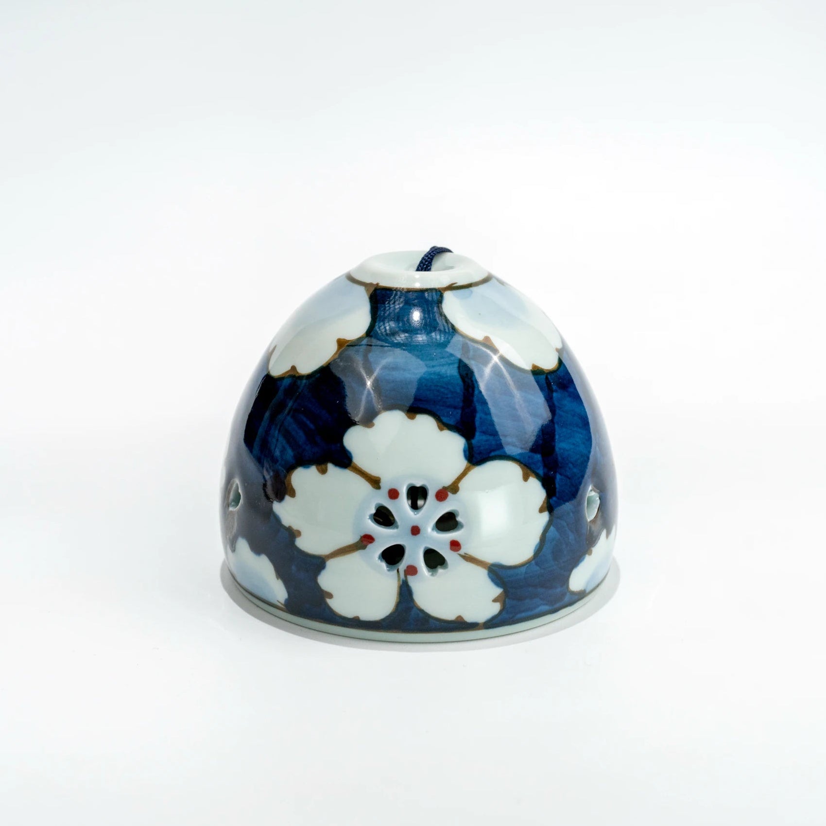 Front view of Arita floral openwork porcelain wind chime bell