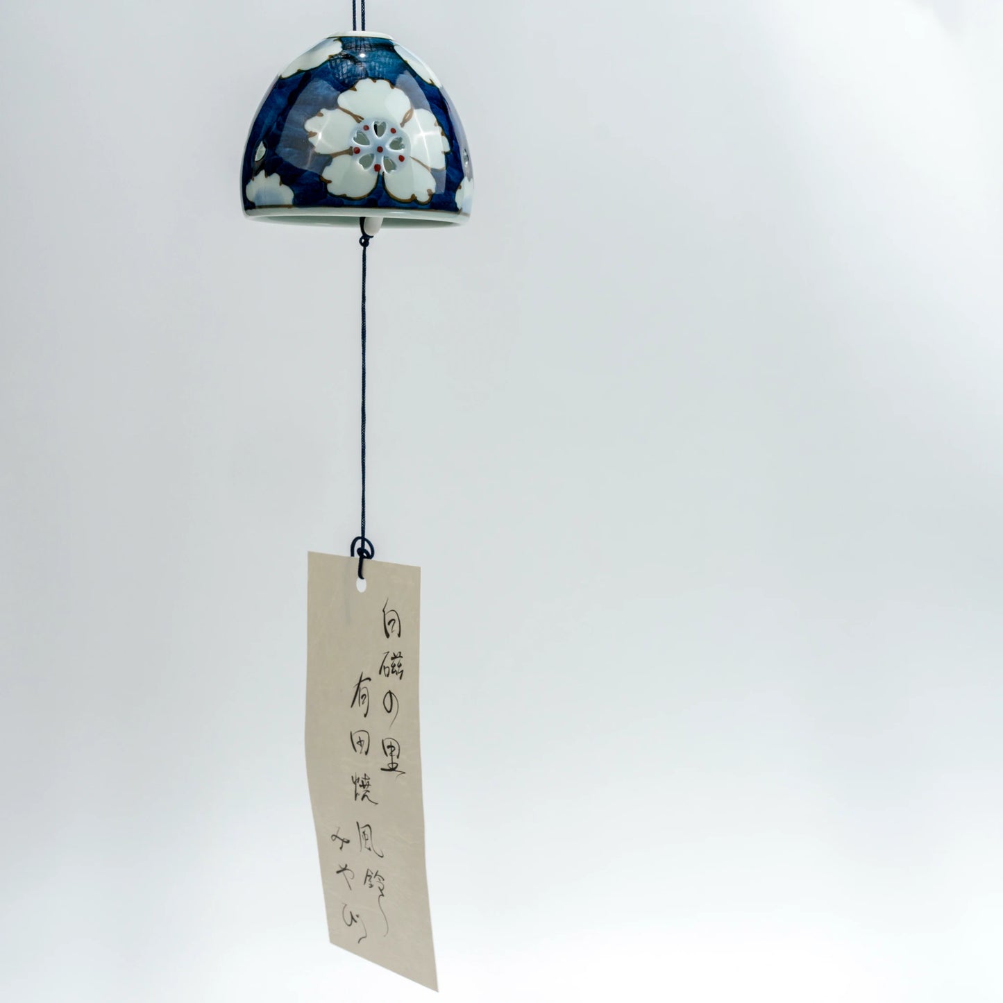 Full hanging view of Arita floral openwork wind chime with decorative paper strip