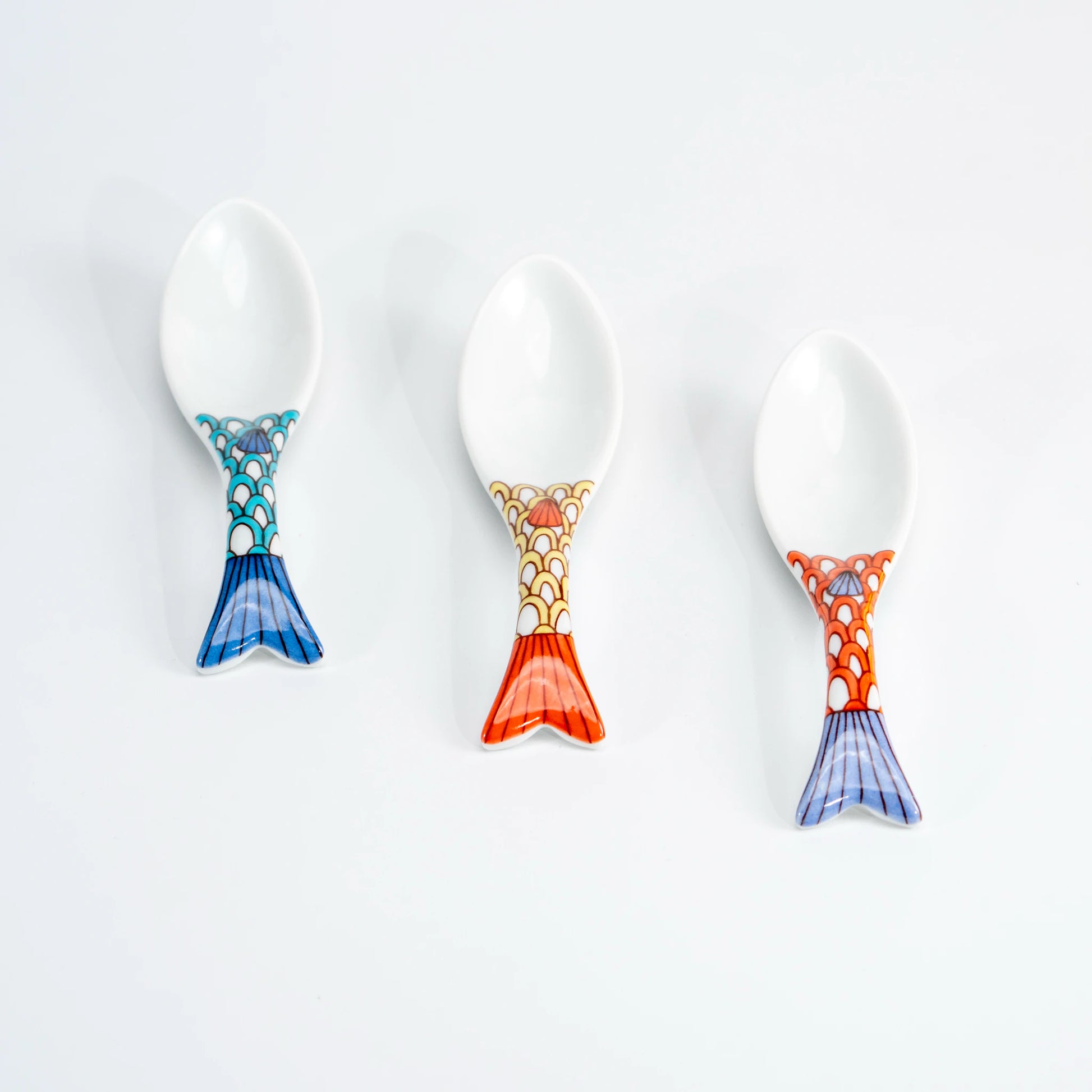 Top view of three Kutani whale renge spoons showing blue, yellow, and purple color options