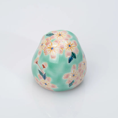 Back view of aqua Kutani Daruma covered in pink cherry blossoms