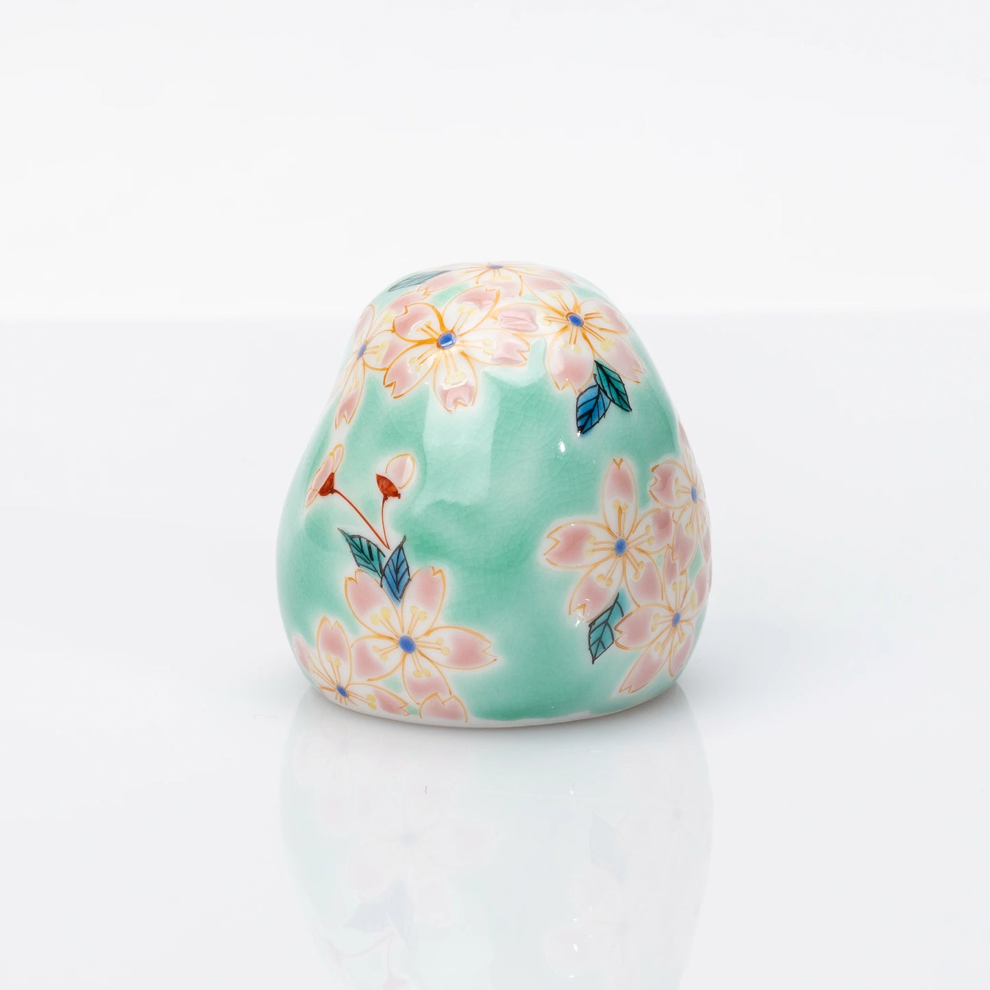 Rear view showing pink cherry blossoms on aqua Kutani Daruma