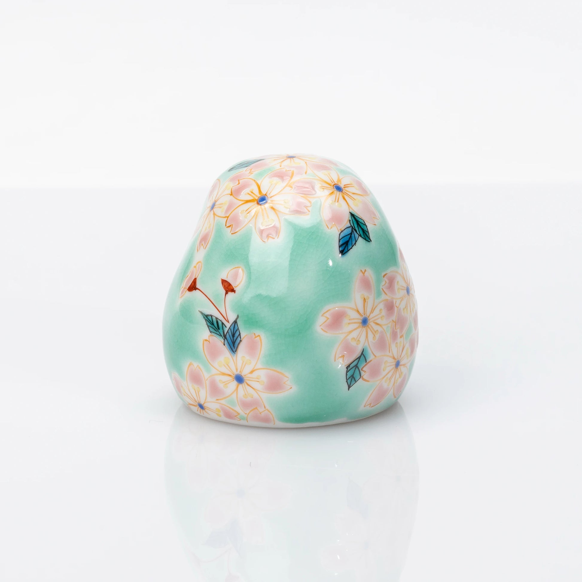 Rear view showing pink cherry blossoms on aqua Kutani Daruma