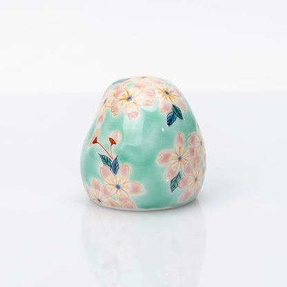 Rear view showing pink cherry blossoms on aqua Kutani Daruma