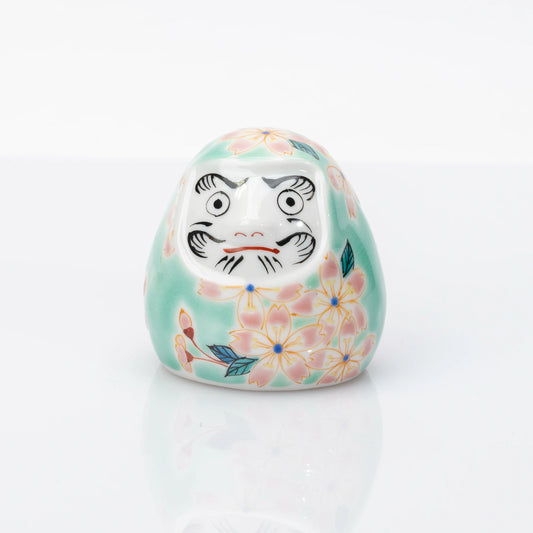 Front view of aqua Kutani Daruma with pink cherry blossom design
