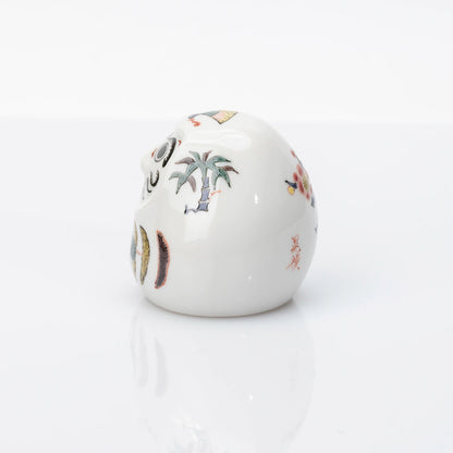 Side view showing bamboo and plum details on Kutani Daruma