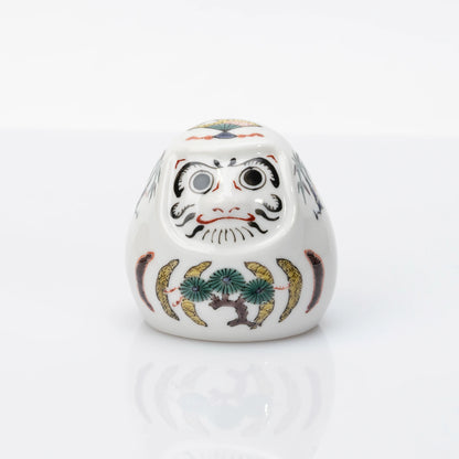 Front view of white Kutani Daruma with pine, bamboo and plum motifs