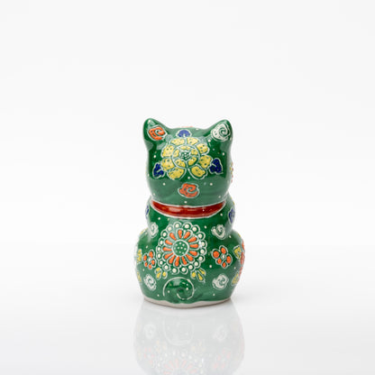 Back of the green praying cat showing yellow and orange flowers, white dots, a red collar, and a curled tail.
