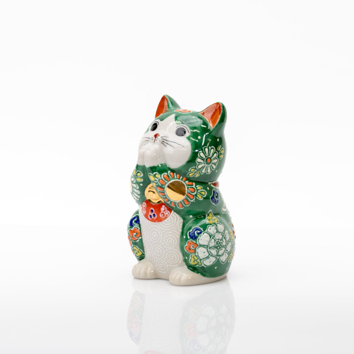 Three-quarter view of the green praying cat with raised white flowers and a spiral-patterned pale belly.