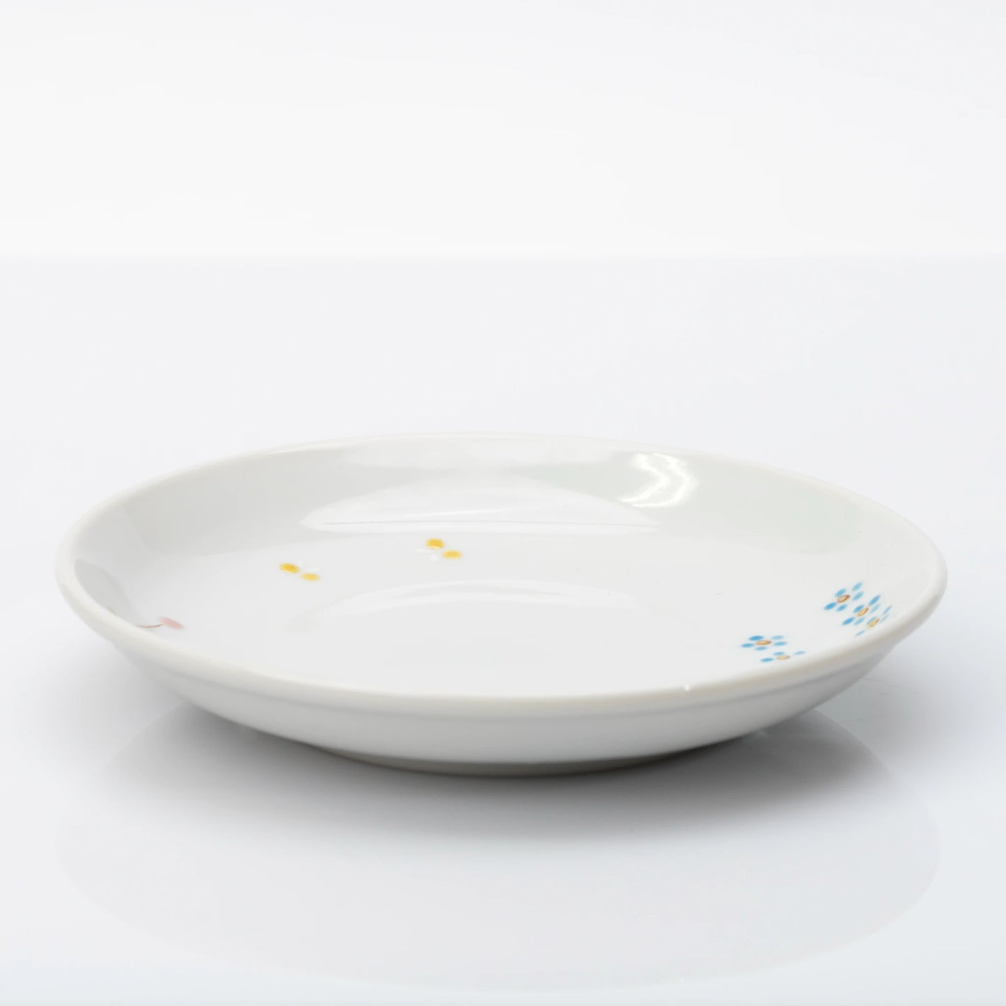 Side profile of white Kutani plate with small floral details