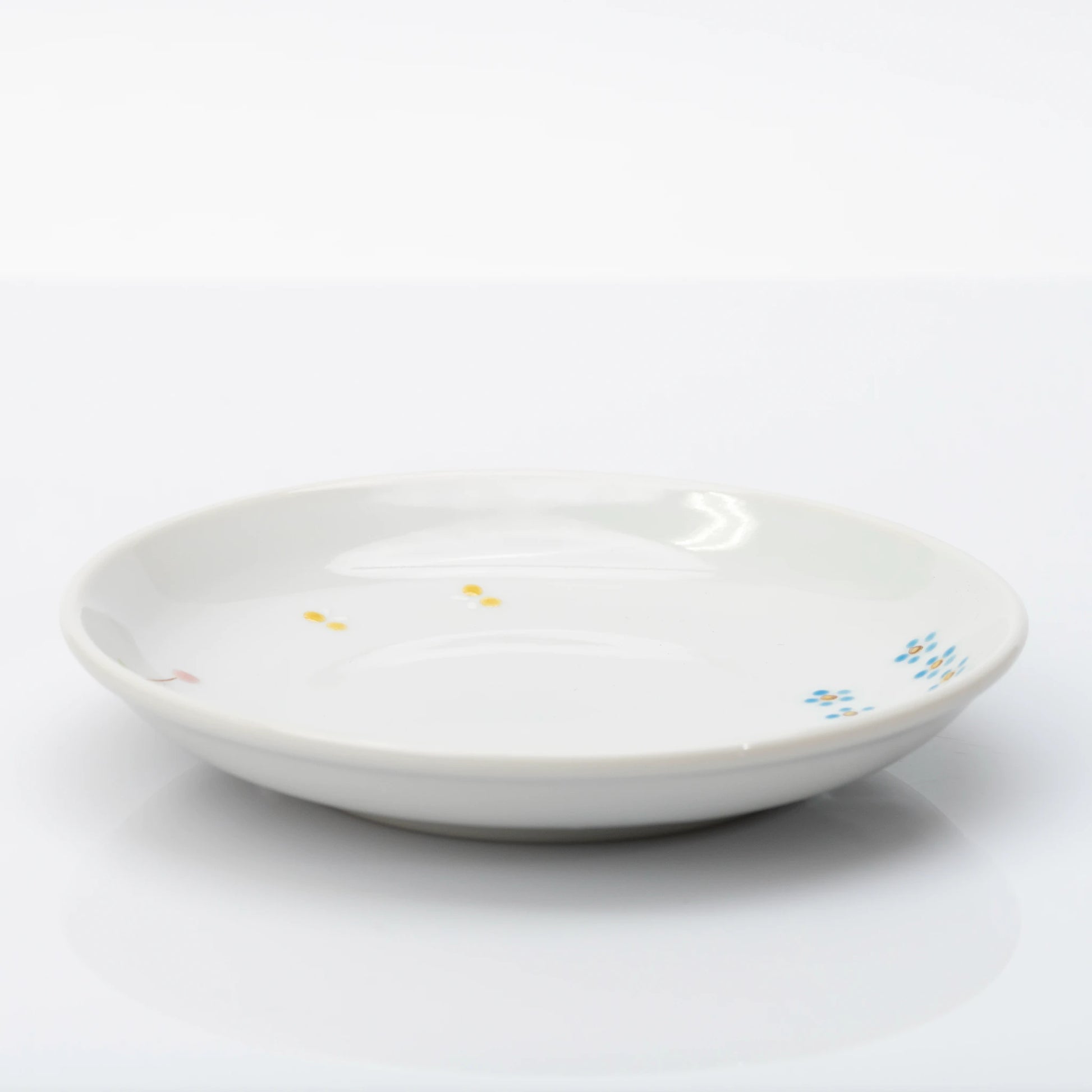 Side profile of white Kutani plate with small floral details