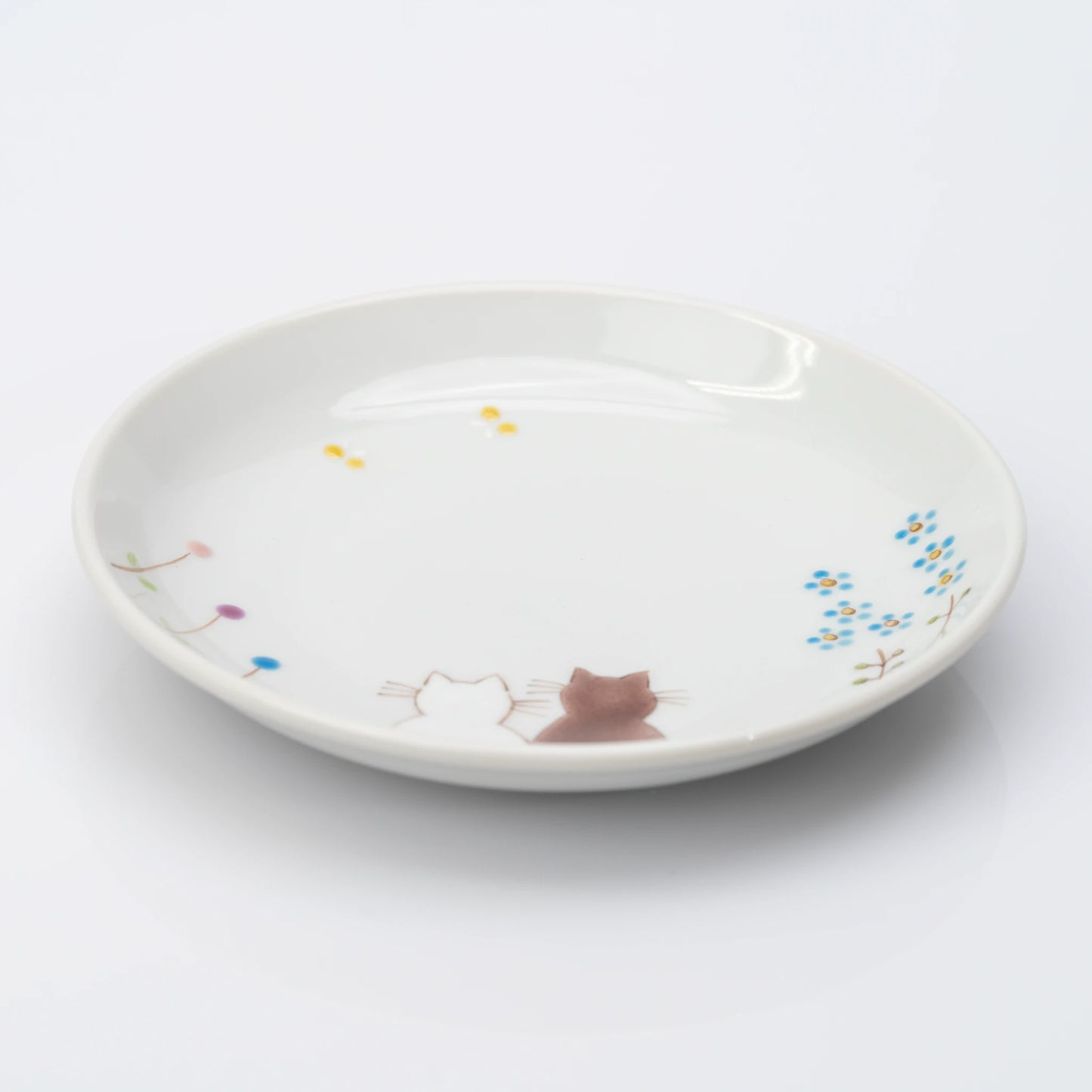 Angled view of white Kutani plate with two cats and delicate flowers