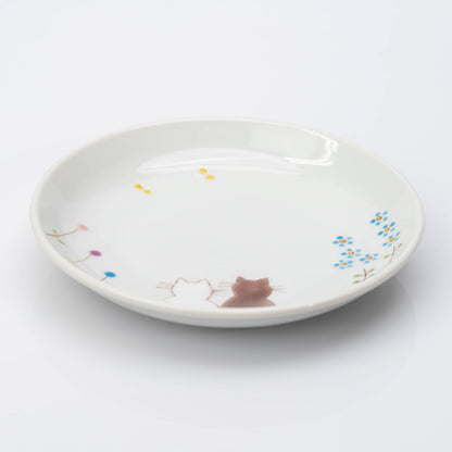 Angled view of white Kutani plate with two cats and delicate flowers